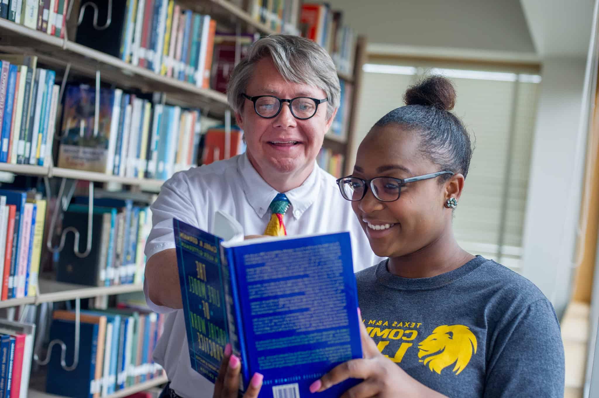 Two people in library looking at a book