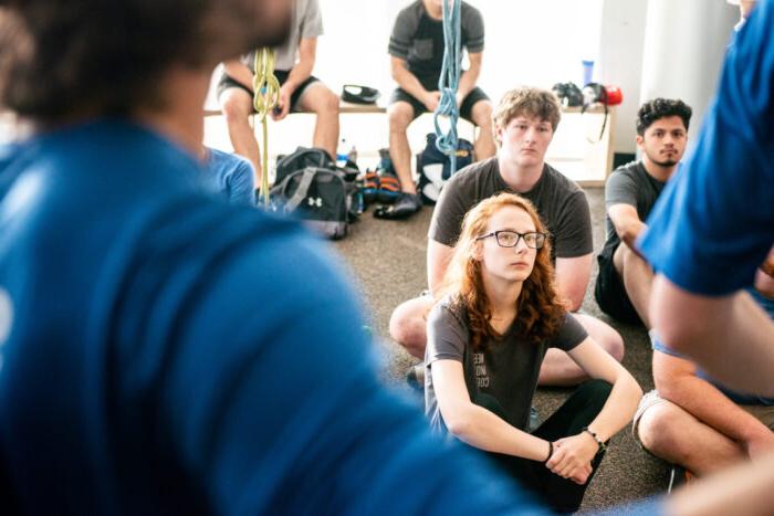 Group of students sitting down listening to professors.