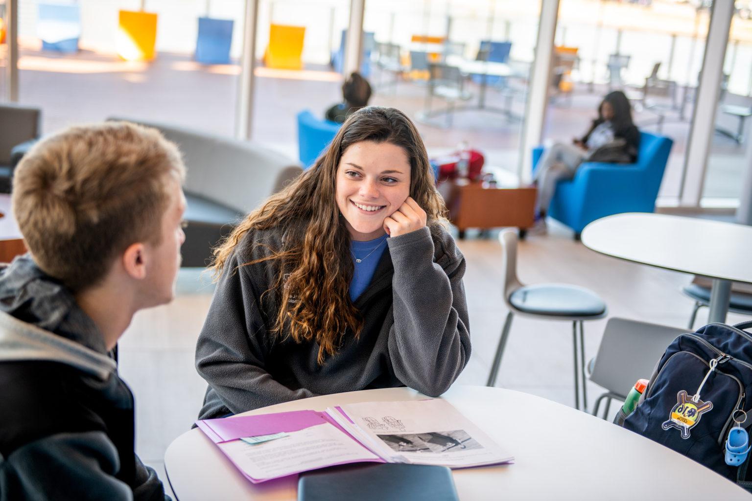 Two college students at table.