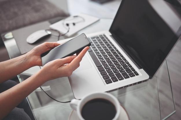 Workstation with laptop, coffee, and phone.